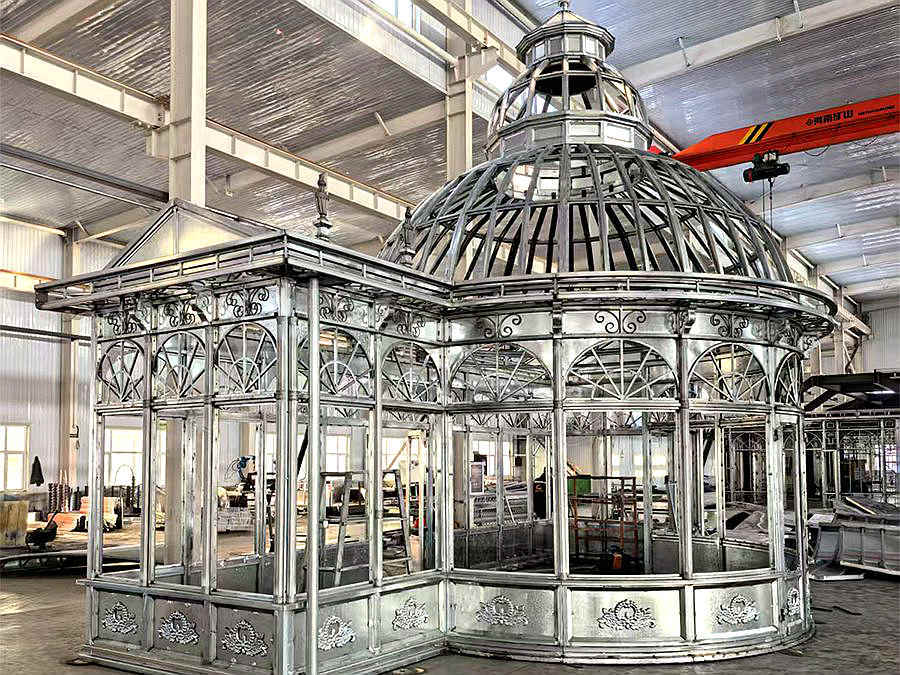 Unfinished hot‑dip galvanized steel frame of victorian dome conservatory inside manufacturing workshop